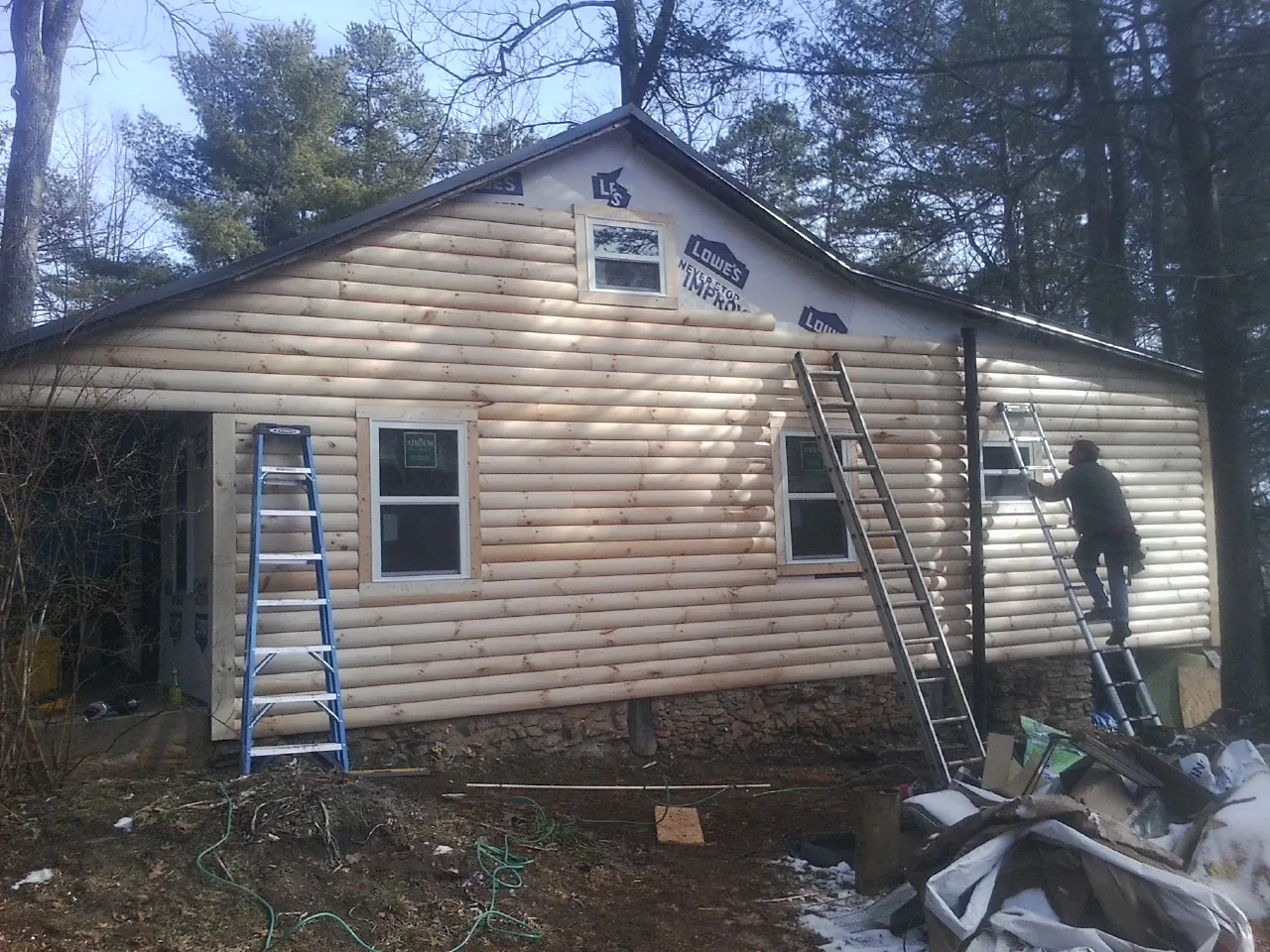 Ladders set against fresh log siding during an exterior remodel in Buffalo Center