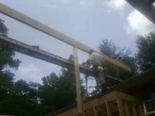 Carpenter setting a ridge beam over a new addition frame — Ice Dam Removal by Roofing Brothers in Buffalo Center